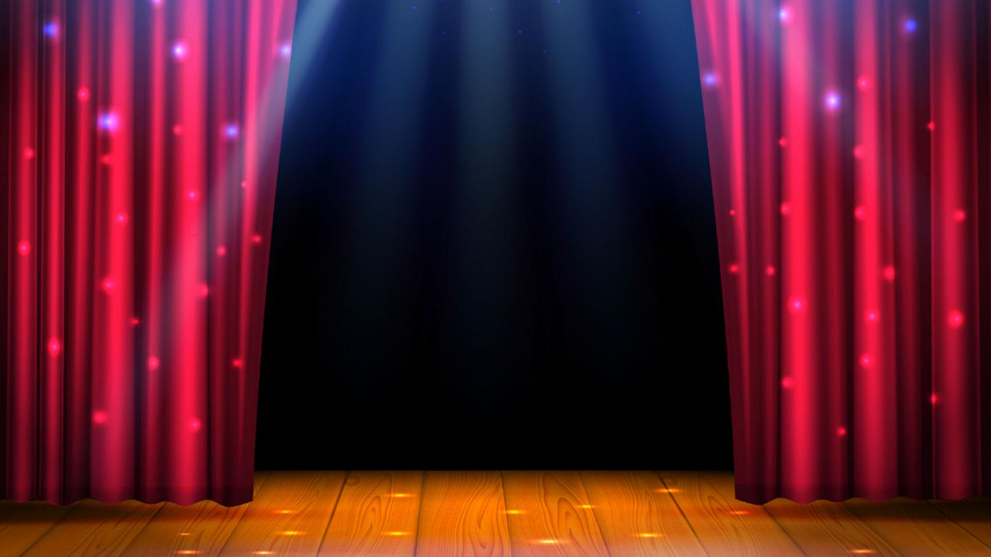 A stage with wooden floor, red curtains parting and the set behind dark, full of possibilities