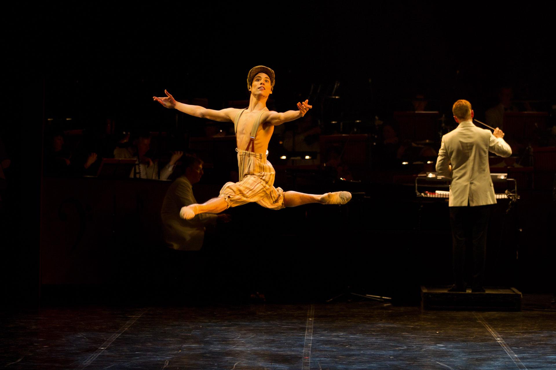 Jumping high wearing only trousers, Kevin Peoung jumps, open arms, to the audience