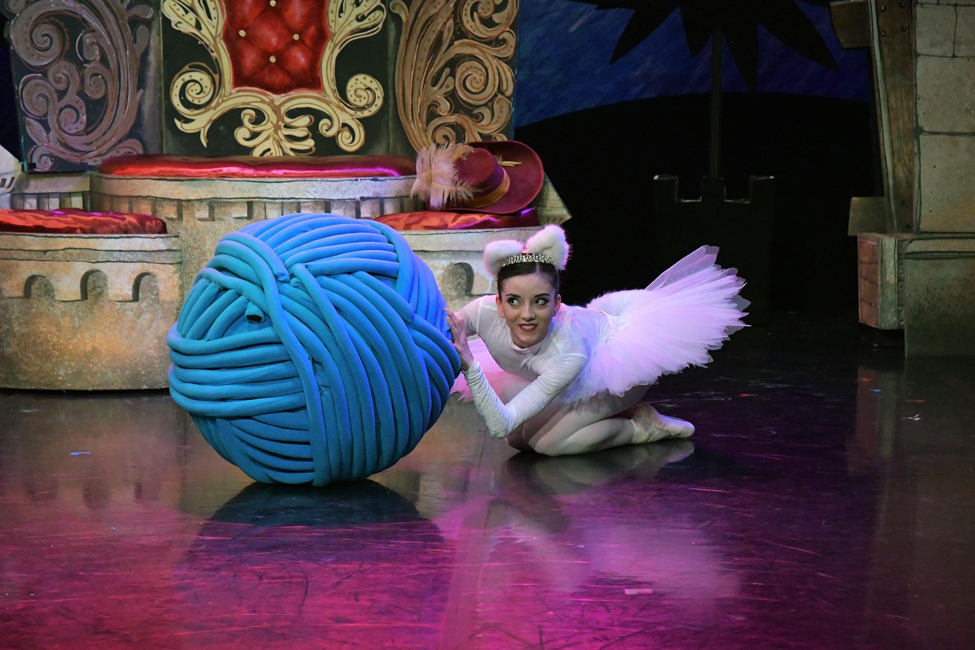 Penelope Purr hides playfully behind a ball of string