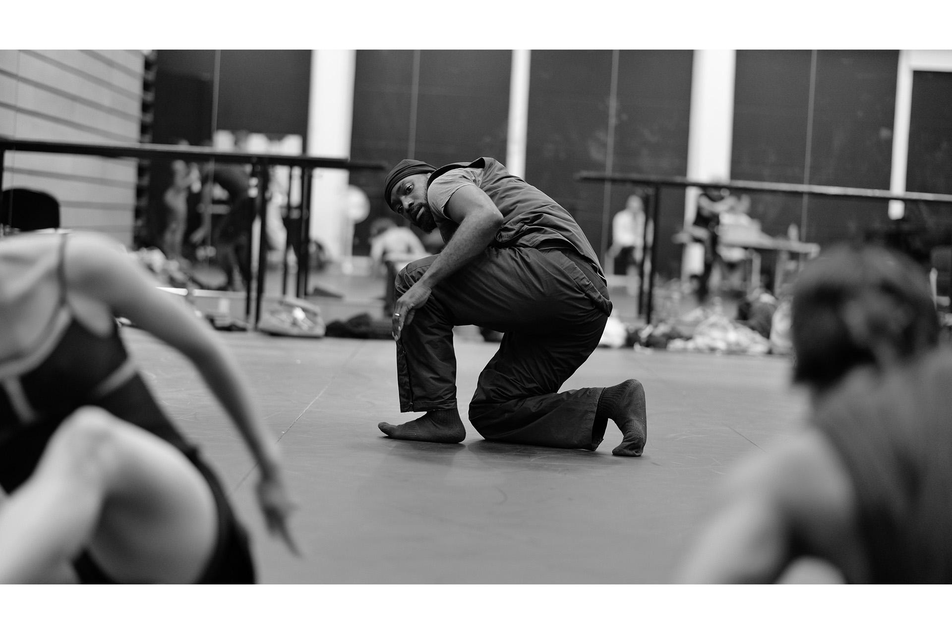 Dickson Mbi kneeling on the the studio floor barefoot
