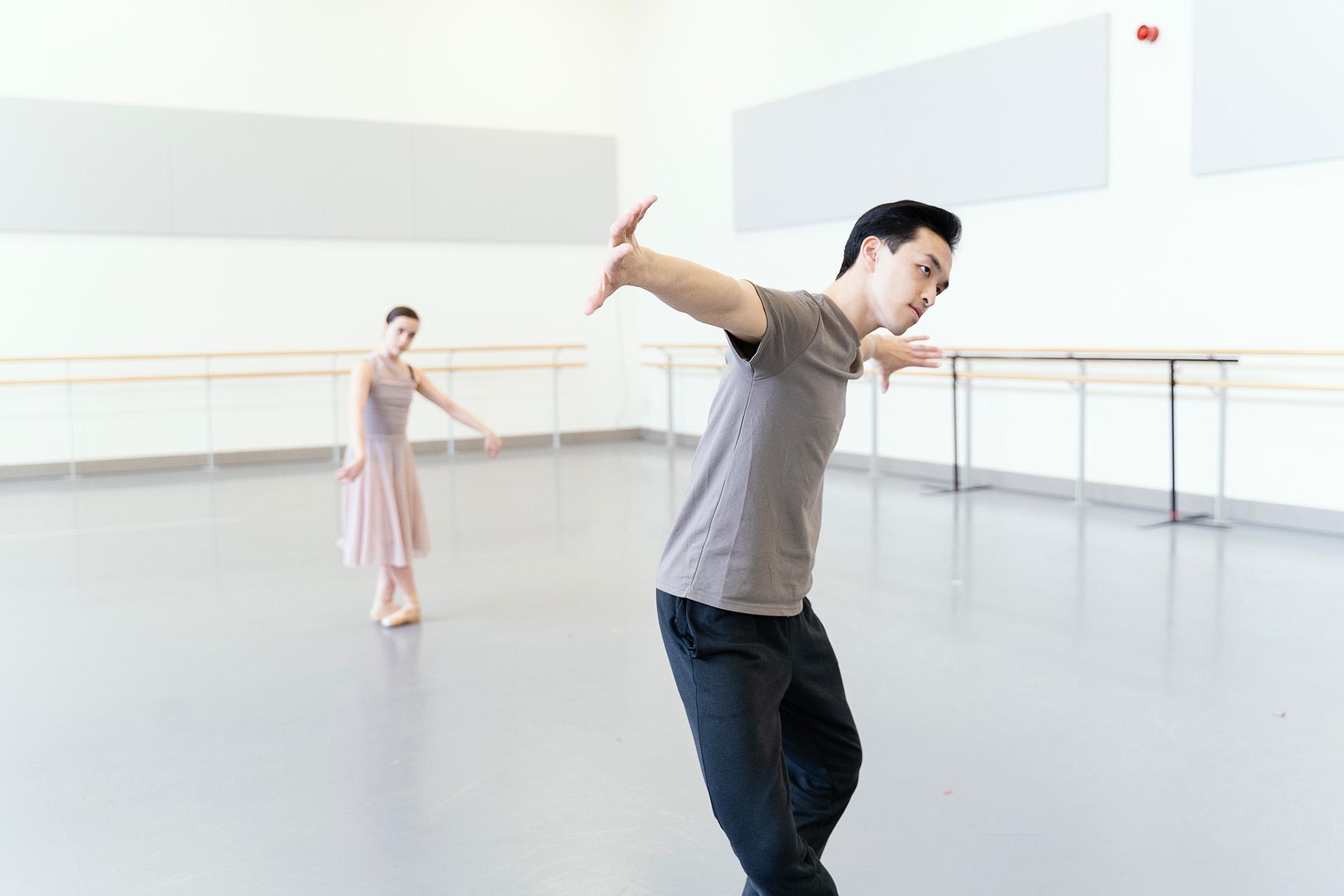 One dancer in the background follows the movements of another in the foreground