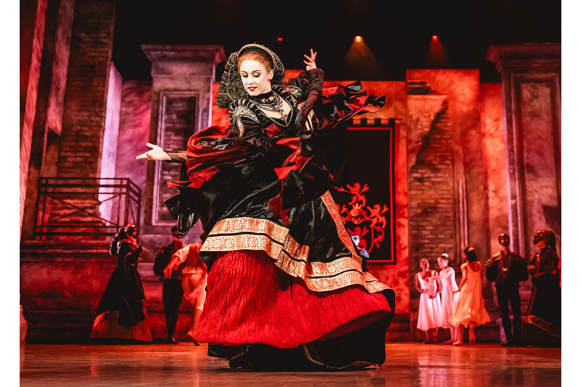 Dancer in black red and gold poses imperiously