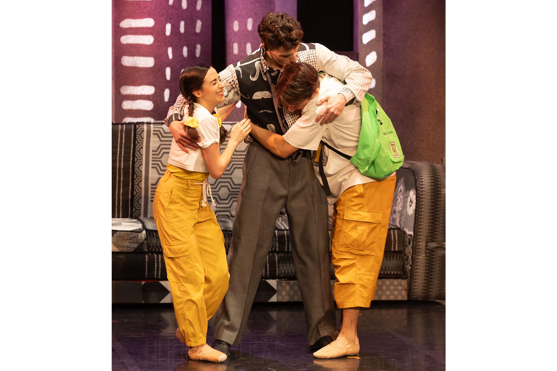 Dad hugs Hansel and Gretel in their living room.