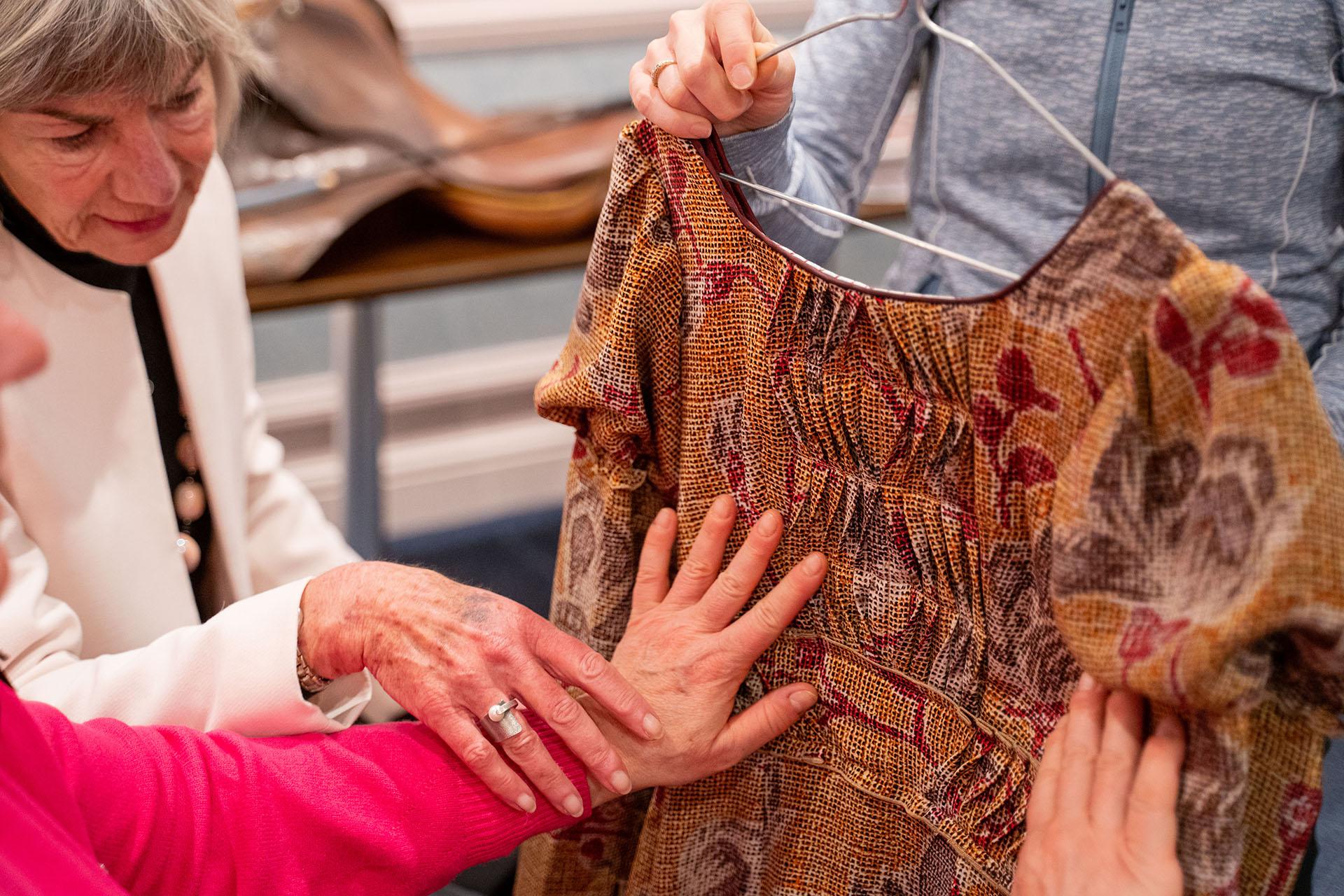 Person feels the costume in front of her, its fold and textures