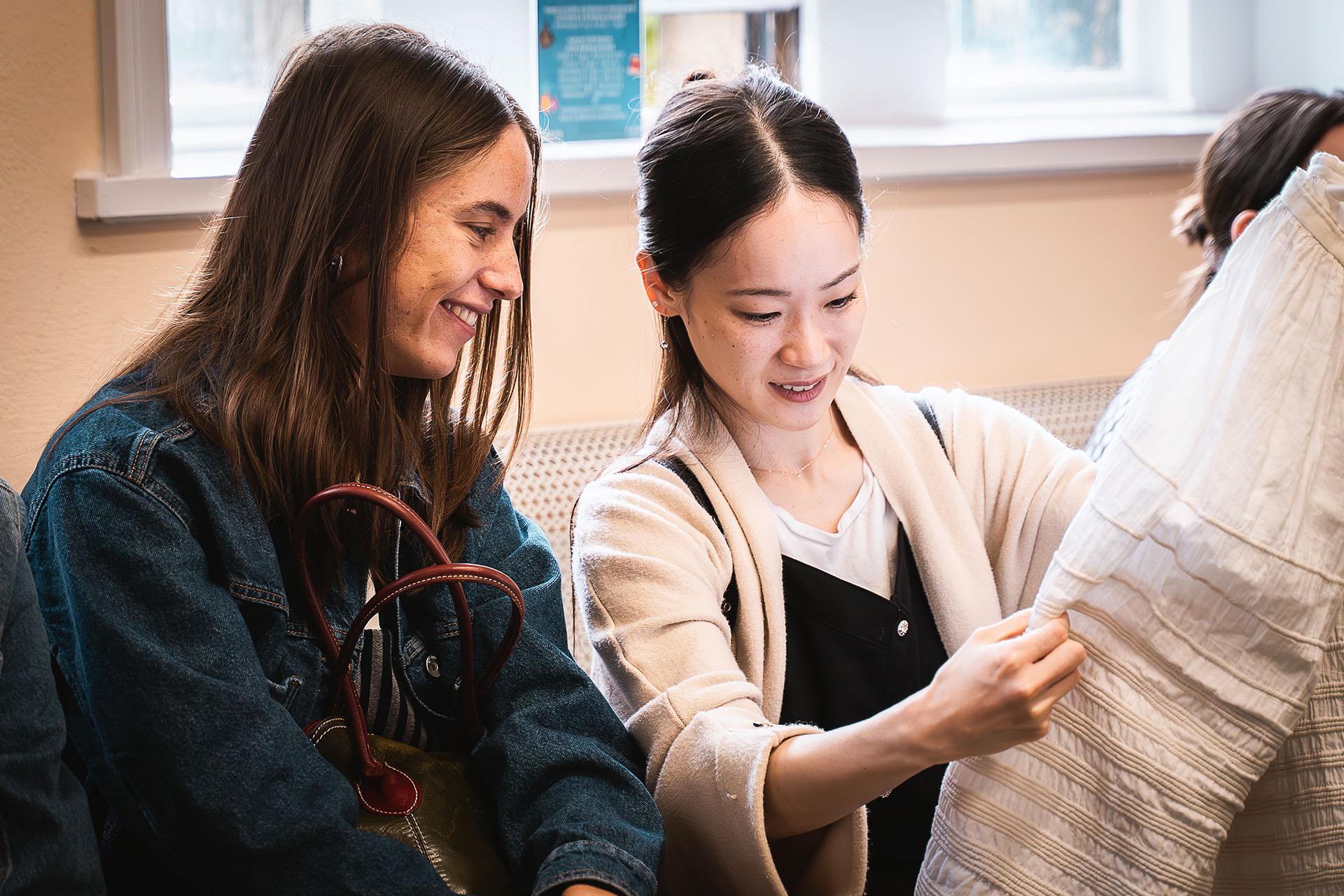 Dancers Saeka Shirai and Gemma Coutts examining 19th Century garments close