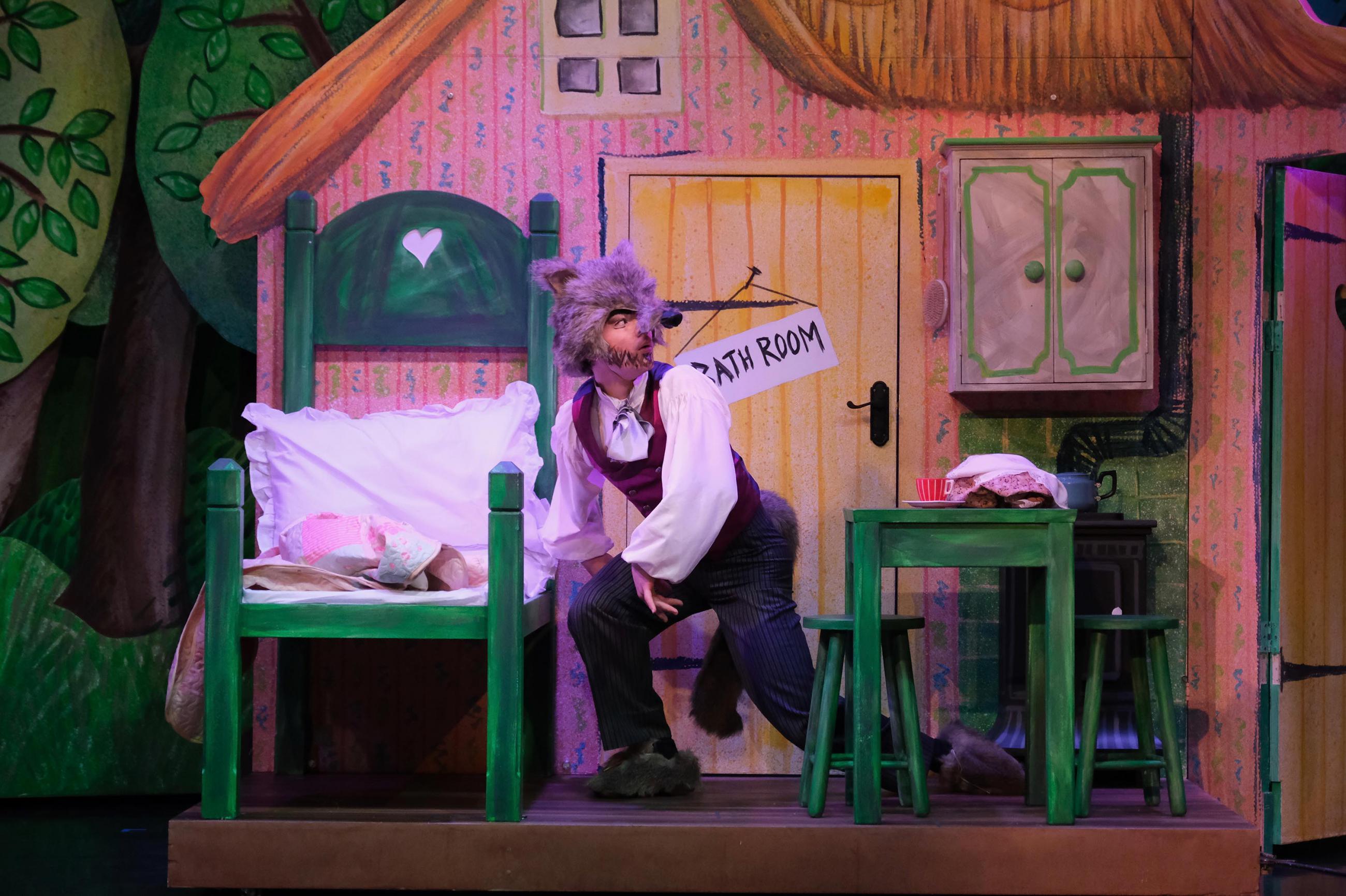 A dancer dressed as a wolf is getting into bed