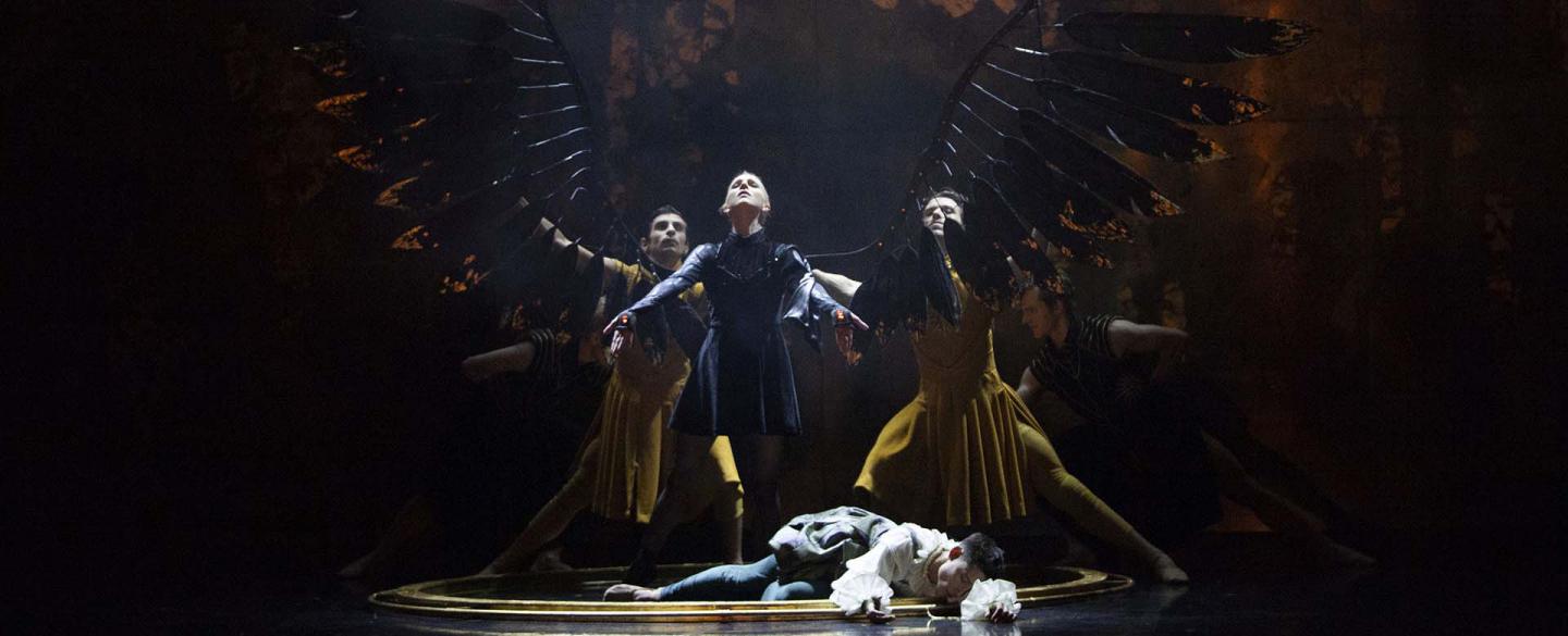 Morgan stands proudly with her new black wings unfurled while Merlin lies drained at her feet