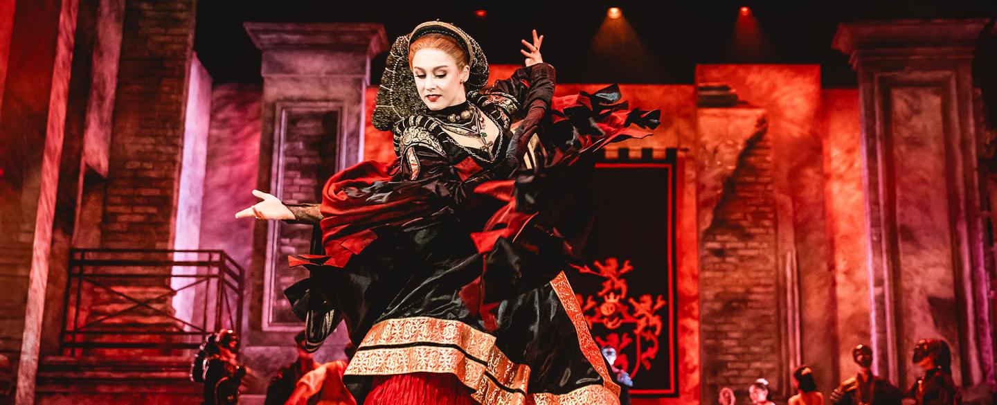 Imperious woman, wearing a red skirt covered with a black dress with heavy gold trimming