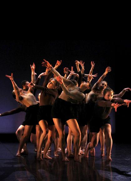 Group of student dancers close together each with their arms outstretched